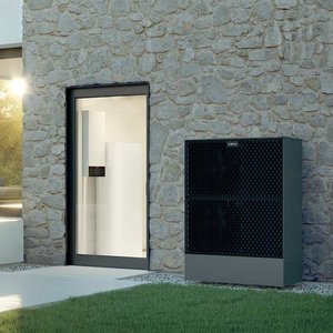 Die Terrasse des Hauses bietet einen Blick auf eine stilvolle Inneneinrichtung mit Pflanzen und gemütlichen Möbeln.