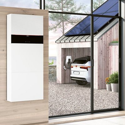 Ein Holzhaus mit einer Photovoltaikanlage und einem E-Auto und einer Wallbox von Vissmann